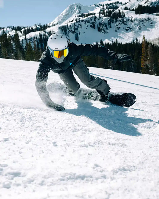snowboarder carving it up on the slopes while wearing a highline ski helmet